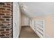Attic hallway with carpet, exposed brick wall and built in storage shelves at 2597 Elsinore St, East Point, GA 30344