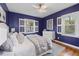 Cozy bedroom featuring wood floors, ceiling fan, and white shuttered windows at 2597 Elsinore St, East Point, GA 30344