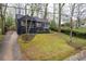 Inviting home with a dark exterior, complemented by a well-kept lawn and a long driveway at 2597 Elsinore St, East Point, GA 30344