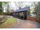 Charming home featuring a dark exterior, a well-manicured lawn, and a private driveway at 2597 Elsinore St, East Point, GA 30344