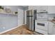 Bright kitchen featuring stainless steel refrigerator, white cabinets, and tile flooring at 2597 Elsinore St, East Point, GA 30344