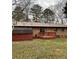 Backyard of brick home features a wood deck, red shed, and mature trees at 40 Chimney Rise Ct, Stockbridge, GA 30281