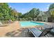 Community pool with lounge chairs and surrounding greenery at 224 Seasons Pkwy, Norcross, GA 30093