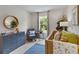 Bright and airy bedroom with a crib, dresser, and rocking chair at 8232 Walnut Hall Dr, Fairburn, GA 30213