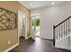 Bright entryway with dark hardwood floors, powder room, and staircase at 8232 Walnut Hall Dr, Fairburn, GA 30213