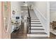 Two-story entryway with hardwood floors, wooden staircase, and decorative console table at 2891 Cooper Woods Dr, Loganville, GA 30052