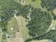 Aerial view showing a home nestled in a large, wooded lot with several outbuildings at 416 Spring Place Ne Rd, White, GA 30184