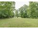 Serene backyard with lush lawn, mature trees, and distant views at 416 Spring Place Ne Rd, White, GA 30184