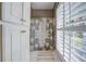 Bathroom with shower stall, white cabinets and plantation shutters at 416 Spring Place Ne Rd, White, GA 30184