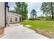 Backyard featuring a covered patio, green lawn, and mature trees at 814 Sunny Field Ln, Lawrenceville, GA 30043