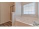 Bathroom featuring a soaking tub, a glass-enclosed shower, and wood-look tile flooring at 814 Sunny Field Ln, Lawrenceville, GA 30043