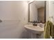 Cozy powder room features a pedestal sink, accent mirror, and towel rack at 814 Sunny Field Ln, Lawrenceville, GA 30043