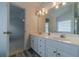 Bathroom featuring a dual sink vanity, a large mirror, and wood-look tile flooring at 814 Sunny Field Ln, Lawrenceville, GA 30043