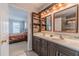 Well-lit bathroom featuring a double vanity with dark wood cabinets and decorative mirrors at 814 Sunny Field Ln, Lawrenceville, GA 30043