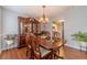 Dining room with hardwood floors, chandelier, dining table, and a view into the kitchen at 814 Sunny Field Ln, Lawrenceville, GA 30043