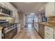 Well-lit kitchen featuring modern appliances, granite countertops, and tile backsplash with a view to the living room at 814 Sunny Field Ln, Lawrenceville, GA 30043