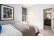 A lovely bedroom featuring artwork, a window with a shade, and a view into the bathroom at 2057 Telfair Cir, Atlanta, GA 30324