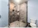 Glass-enclosed shower features gray stone tiling and a built-in soap niche at 2057 Telfair Cir, Atlanta, GA 30324