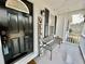Stylish front porch with a black front door, welcome sign, bench, and decorative lighting at 4320 Center Hill Church Rd, Loganville, GA 30052