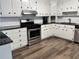 Modern kitchen featuring white cabinets, granite countertops, and stainless steel appliances at 4320 Center Hill Church Rd, Loganville, GA 30052