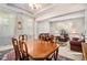 Inviting dining room featuring wood table with chairs, chandelier, and views into the living room at 436 Margaux Way, Atlanta, GA 30349
