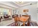 Open-concept dining area with wood table, chairs, and decorative chandelier leading to a cozy living room at 436 Margaux Way, Atlanta, GA 30349