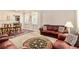 Comfortable living room featuring neutral carpet, leather couches, area rug, and natural light at 436 Margaux Way, Atlanta, GA 30349