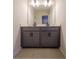 Double vanity bathroom with gray cabinets and a large mirror at 776 Clifftop Crossing, Powder Springs, GA 30127