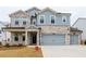 Two-story house with stone and shingle accents, two-car garage, and landscaping at 776 Clifftop Crossing, Powder Springs, GA 30127