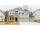 Two-story house with stone and shingle accents, two-car garage, and landscaping at 776 Clifftop Crossing, Powder Springs, GA 30127