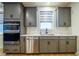 Modern kitchen with gray cabinets, quartz countertops, and stainless steel appliances at 776 Clifftop Crossing, Powder Springs, GA 30127