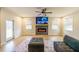 Living room with fireplace, mounted television, modern ceiling fan, two windows, and hardwood floors at 776 Clifftop Crossing, Powder Springs, GA 30127