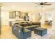 Open living room featuring a sectional sofa, hardwood floors, and a view into the kitchen at 776 Clifftop Crossing, Powder Springs, GA 30127