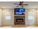 Living room featuring fireplace, mounted television, two windows with shades, and hardwood floors at 776 Clifftop Crossing, Powder Springs, GA 30127