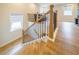 Staircase with a wooden railing and hardwood floors near the living room with a large window at 776 Clifftop Crossing, Powder Springs, GA 30127