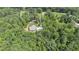 Aerial view reveals a charming home surrounded by lush trees, featuring a long driveway and a detached garage at 764 Little Vine Church Rd, Villa Rica, GA 30180