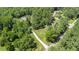 Aerial view showcases the home's long driveway leading to a secluded property surrounded by lush, mature trees and greenery at 764 Little Vine Church Rd, Villa Rica, GA 30180