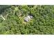 Aerial view of a cozy home nestled within a lush forest, featuring a well-manicured lawn and a detached garage at 764 Little Vine Church Rd, Villa Rica, GA 30180