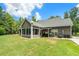 Lush backyard featuring a sunroom, covered patio, and a well-maintained lawn at 764 Little Vine Church Rd, Villa Rica, GA 30180