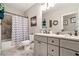 Full bathroom features double vanity with decorative lighting, soaking tub, and shower with chevron curtain at 764 Little Vine Church Rd, Villa Rica, GA 30180