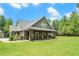 Charming home featuring a welcoming front porch with wood columns, lush lawn, and beautiful landscaping at 764 Little Vine Church Rd, Villa Rica, GA 30180