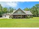Beautiful home with a spacious front lawn, covered front porch, and a detached three-car garage at 764 Little Vine Church Rd, Villa Rica, GA 30180