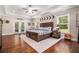 Spacious main bedroom with tray ceiling, hardwood floors, and French doors leading to outdoor space at 764 Little Vine Church Rd, Villa Rica, GA 30180