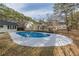 Inviting kidney-shaped swimming pool with concrete decking and surrounding trees at 7020 Camp Valley Rd, Riverdale, GA 30296