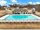 Community swimming pool with adjacent clubhouse and residential homes at 1018 Cherry Bark Ln, Loganville, GA 30096