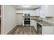 Modern kitchen featuring stainless steel appliances, ample cabinet space, and stylish flooring at 5925 S Quail Dr, Douglasville, GA 30135