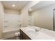 Clean bathroom with vanity, sink, large mirror, and bathtub-shower combo with shelving at 148 Oliver Dr, Locust Grove, GA 30248