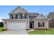 Charming two-story home featuring a mix of stone and brick, a two-car garage, and well-maintained lawn at 148 Oliver Dr, Locust Grove, GA 30248