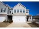 Two-story townhome with gray siding, white garage door, and landscaping at 38 Rocky Knl, Dallas, GA 30157