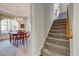 Charming dining area adjacent to carpeted stairs, featuring a chandelier and large window at 5712 Overlook Cir, Powder Springs, GA 30127